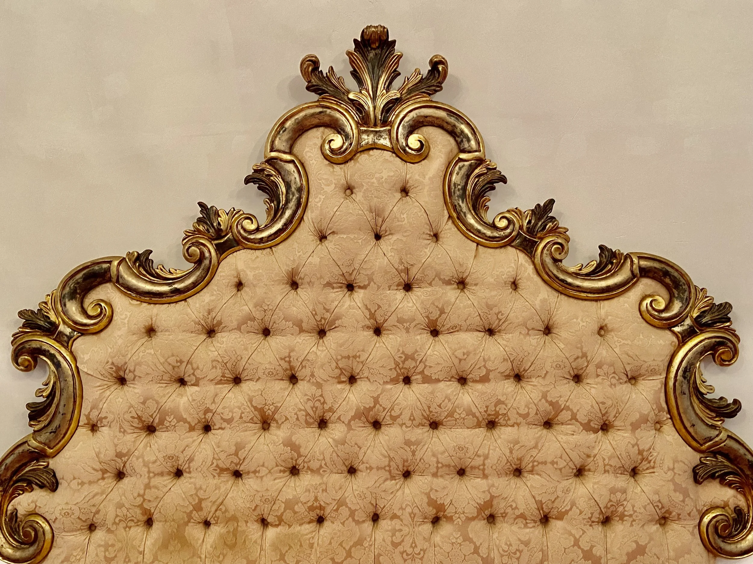 Ornate tufted headboard with gold and floral details