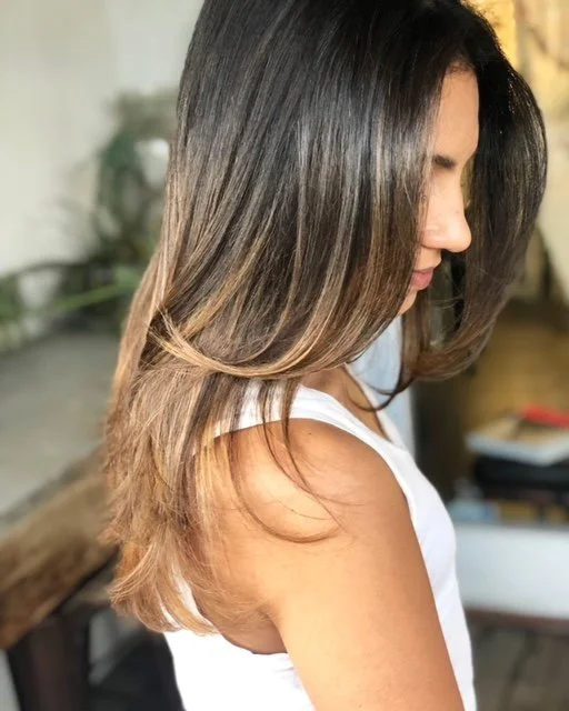 Side view of a woman with shoulder-length, ombré hair in natural light.