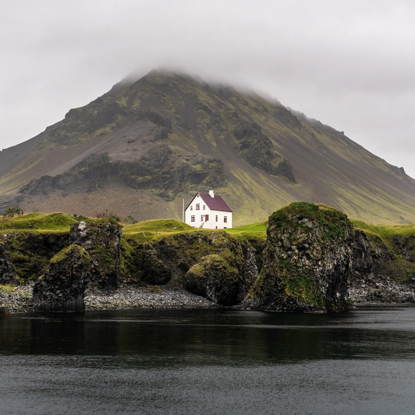 In the heart of Sn&aelig;fellsnes Peninsula, Arnarstapi holds one of photography's most sought after compositions. The white house beneath the brooding mountain, framed by twisted basalt columns that emerge from the sea, creates a scene of raw Nordic