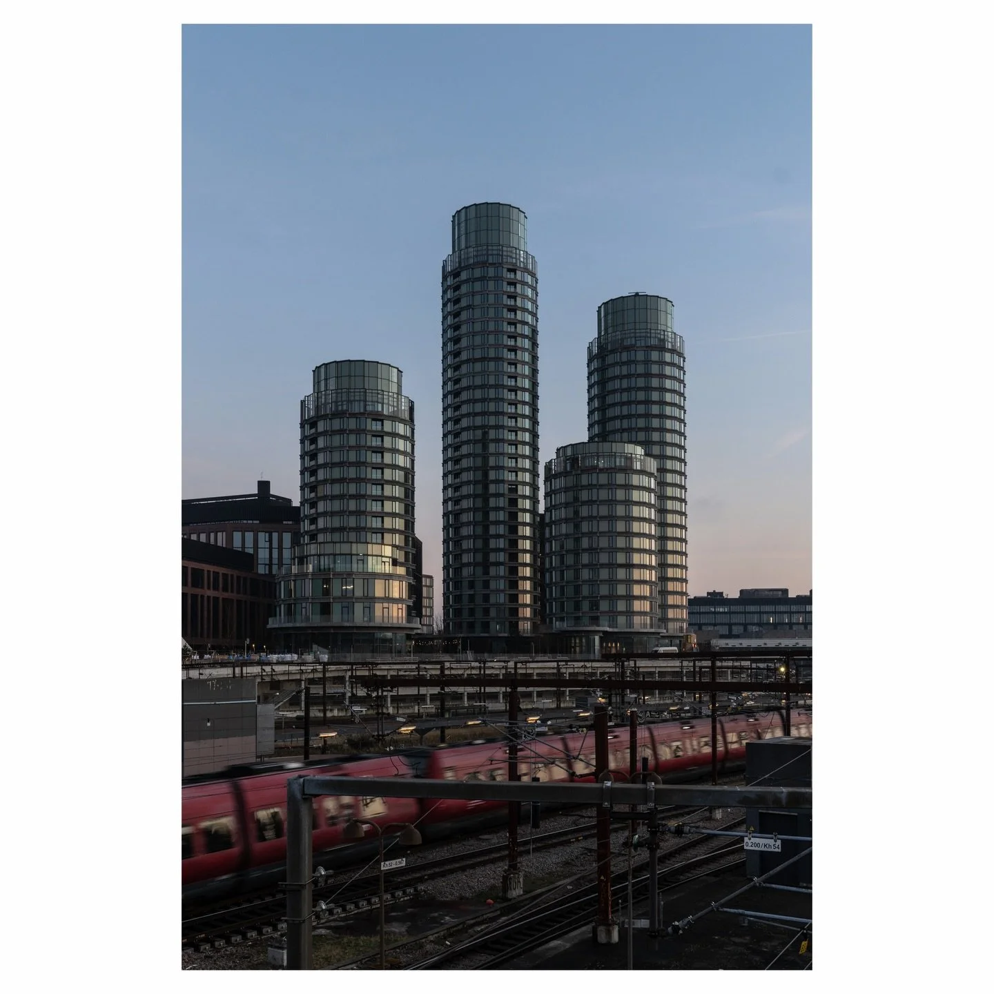 Postbyen&rsquo;s cylindrical towers rise above the railway tracks near Copenhagen Central Station. The district transforms what was once postal headquarters into mixed-use urban space.
📌 Copenhagen, Denmark
✁&mdash;&mdash;&mdash;&mdash;&mdash;&mdash