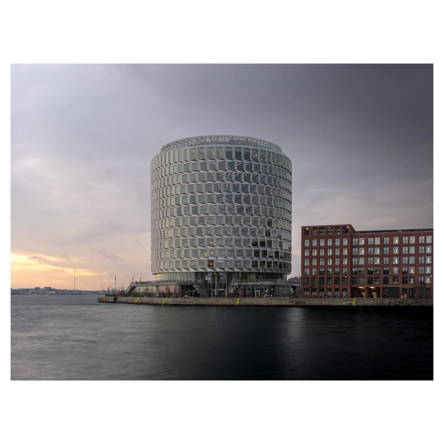Sixty meters of glass and galvanized steel, shaped by hour-by-hour weather simulations and inspired by the industrial silos that once defined this harbour. The Tip of Nord&oslash; stands at the entrance to Copenhagen&rsquo;s Nordhavn district as a co