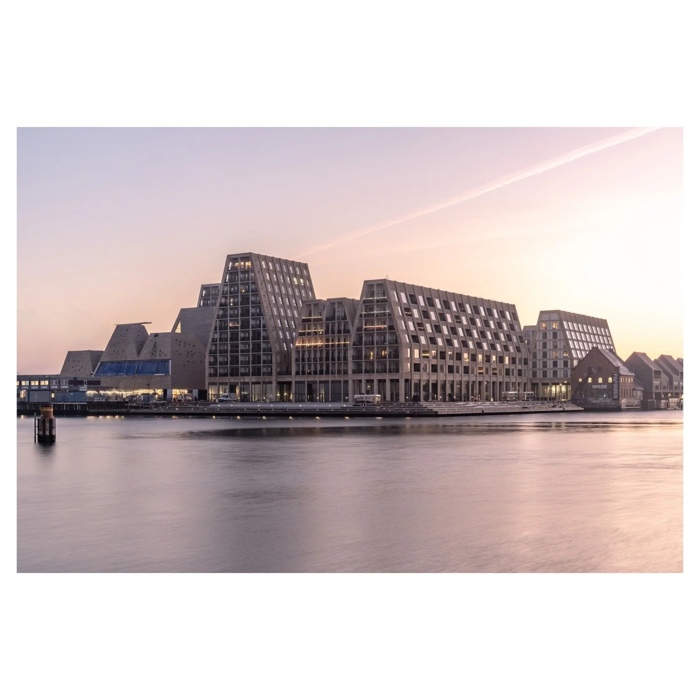 Designed by COBE and inspired by the tall gables of Christianshavn&rsquo;s historic warehouses, Papir&oslash;en has reimagined an entire island from industrial relic into a living neighbourhood. The sloping facades of concrete and brick catch the fir