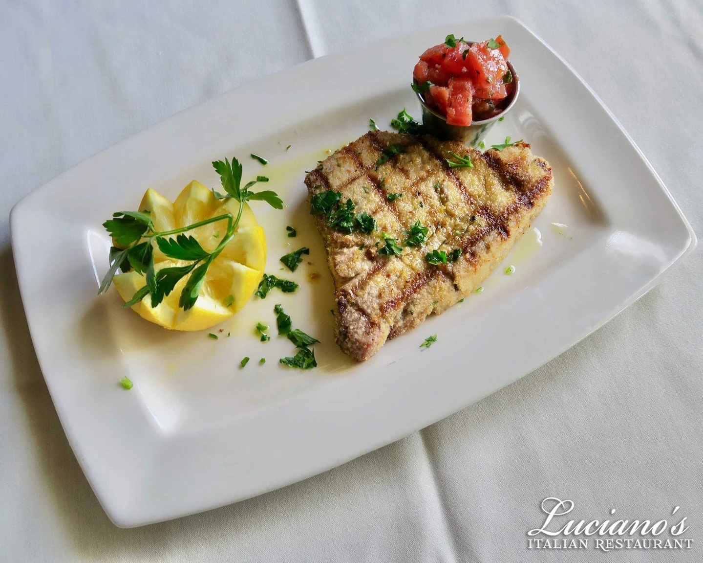 Fresh yellowfin tuna char grilled and topped with olive oil, lemon, and parsley, breaded style and served with Ammoghio - Delicious!