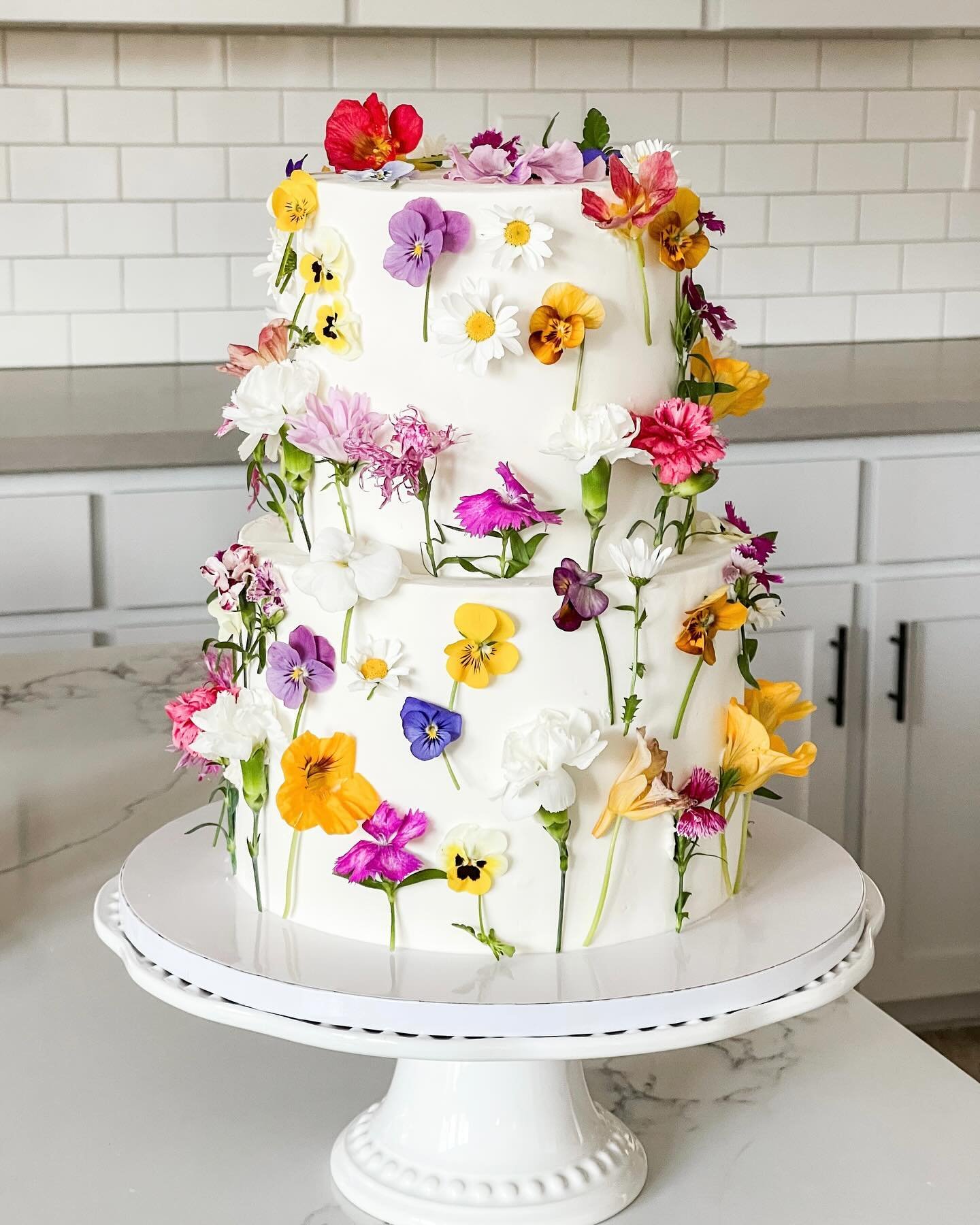 what&rsquo;s better than flowers? 🌸🌷🌼🪻

&hellip;not much! Maybe cake? 😉

Two Tier 6&rdquo; &amp; 8&rdquo; three layer red velvet cake with white buttercream covered in fresh @baskfarm edible floral ✨

#bridalshowercake #flowercake #edibleflowers