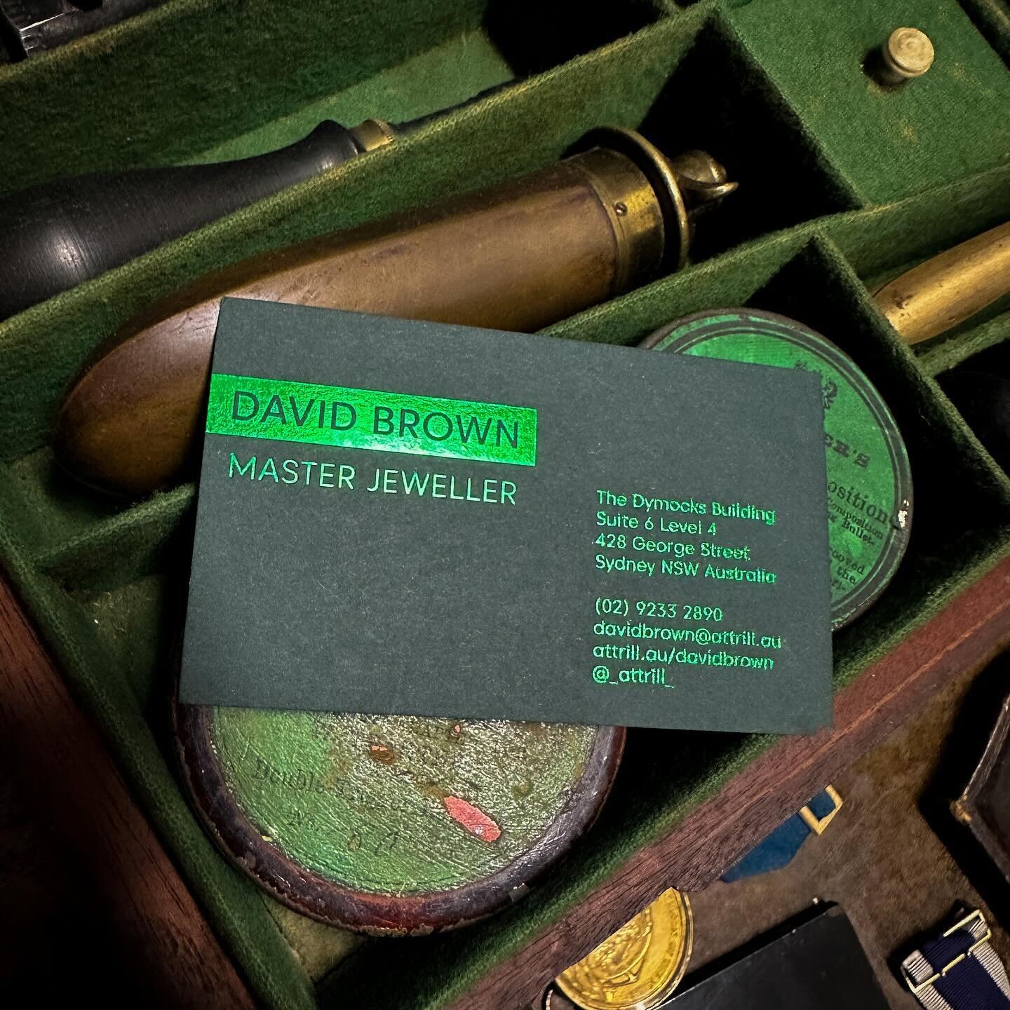 A duplex foil press business card with a green foil edge right at home amongst a collection of militaria. ⚔️ Jewellers always need a touch of luxury and sparkle // #businesscard #attrill #stitchpress