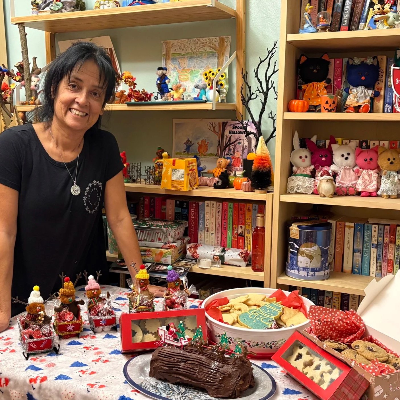 Cynthia in her library, with her wool felt dolls and baked goods