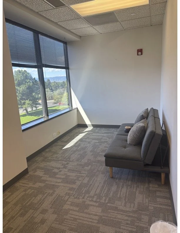 Bright, furnished therapy office available for sublease at Healing Pathways Collective in Centennial, Colorado, with a desk, seating area, and professional workspace.