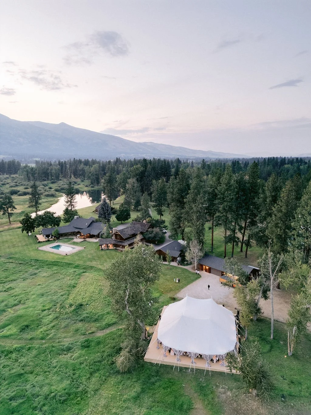 laurie-arons-special-events-montana-family-estate-wedding-aerial-family-estate-striped-tent-lake-mountains-luxury-private-home-wedding-montana.jpg