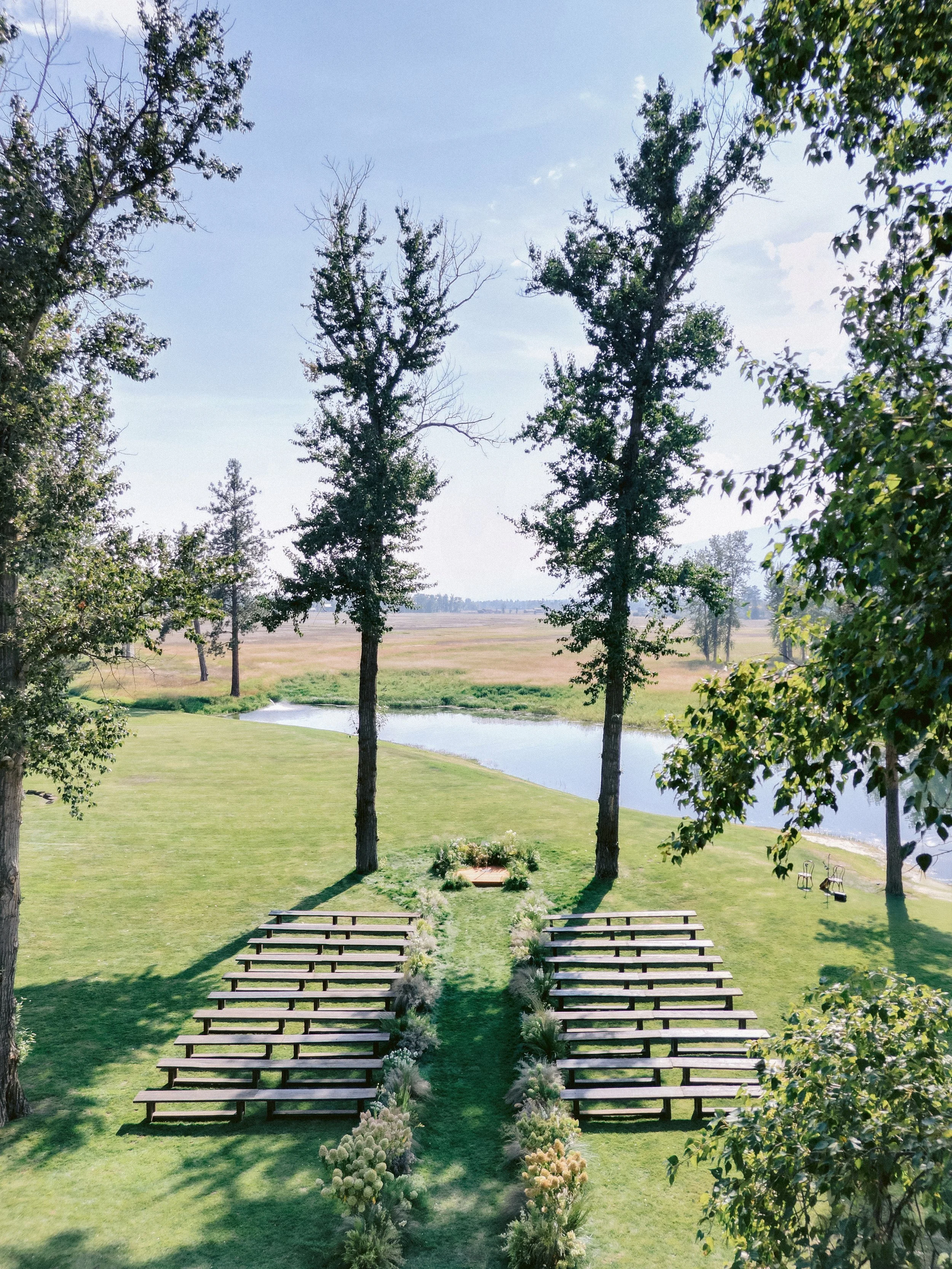 laurie-arons-special-events-montana-ranch-wedding-serene-ceremony-site-rustic-but-elevated-wood-benches-cottonwoods-lake.jpg
