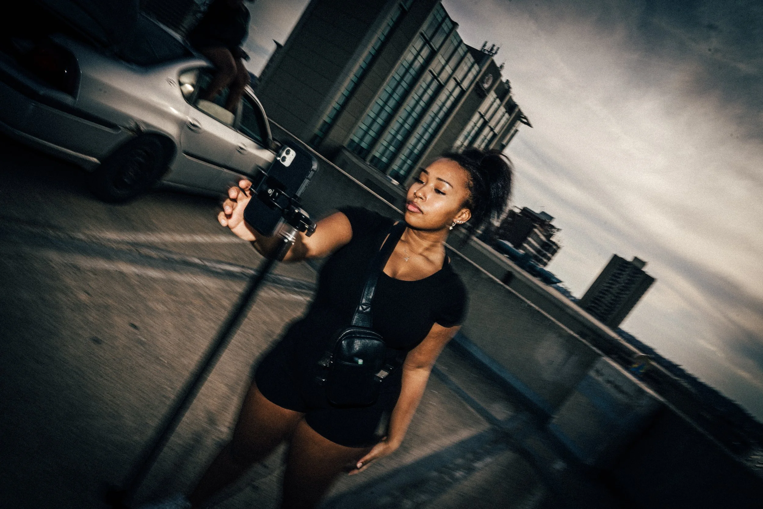 A UGC CONTENT CREATOR GETTING READY TO RECORD CONTENT IN THE MIDDLE OF A STREET