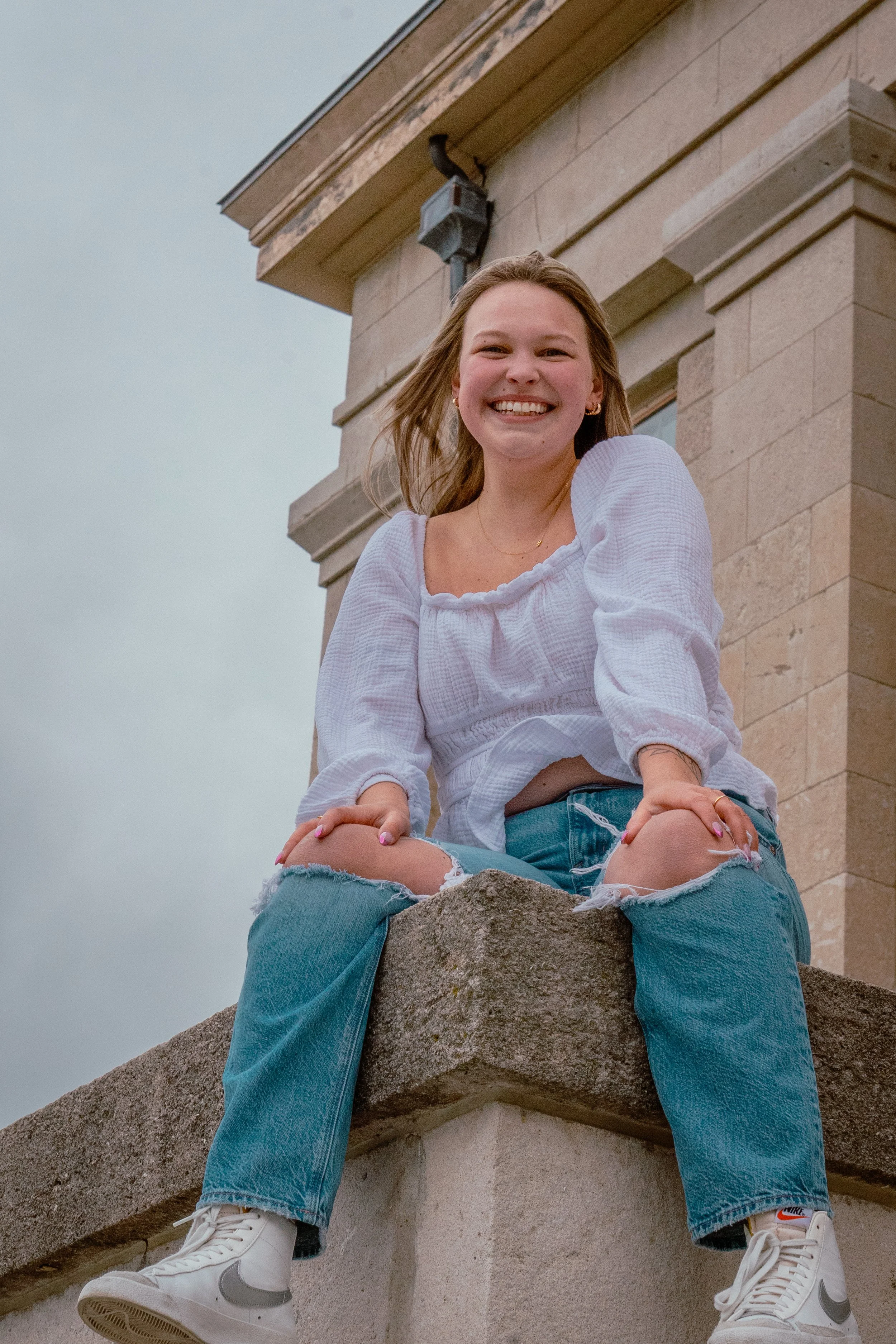 A WOMEN IN FROM OF THE OLD CAP IN IOWA CITY IOWA FOR GRADUATION PHOTOS