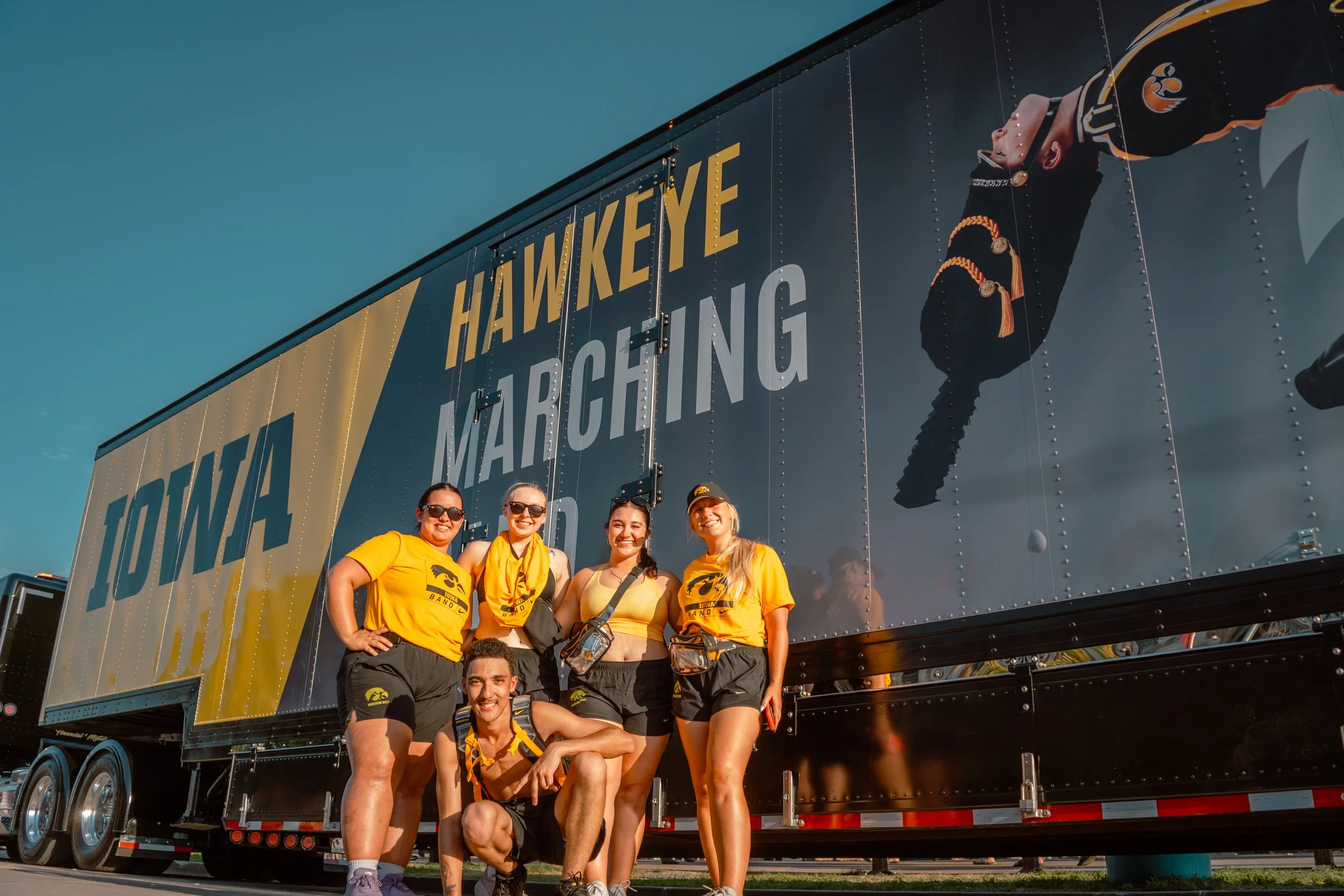 A GROUP OF BAND MEMEBER POSTED UP IN FRONT OF THE BAND'S CUSTOM SEMI- TRUCK