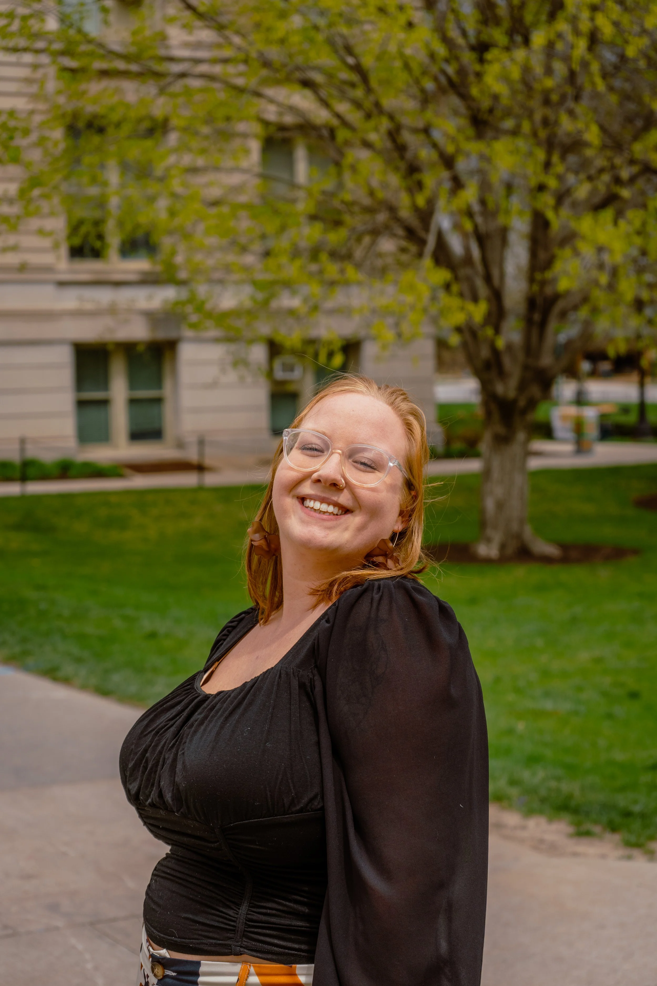 A WOMEN STANDING OUTSIDE OF THE UNIVERSITY IOWA OLD CAPITAL BUILDING FOR GRADUATION PHOTOS