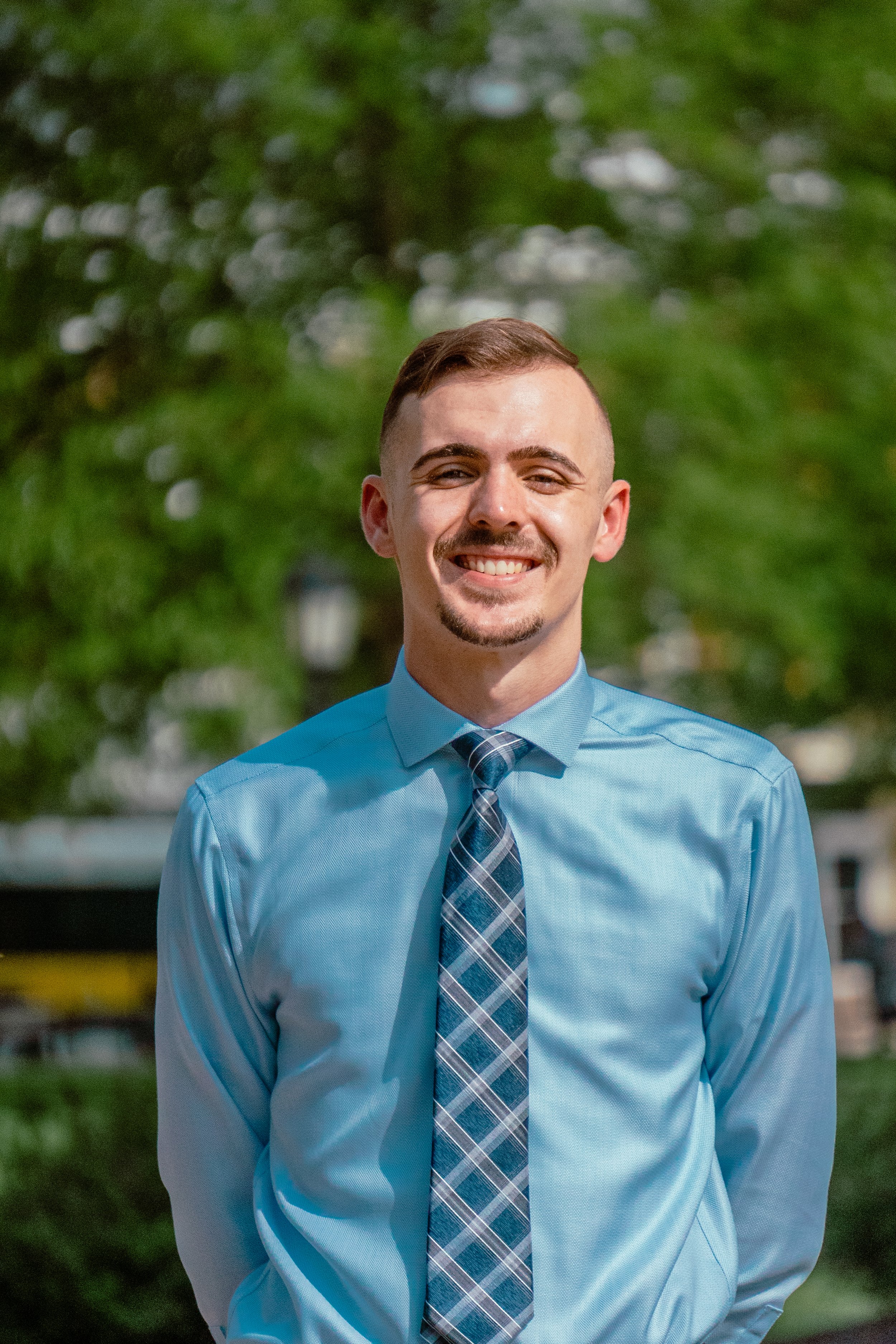 A HEAD SHOT OF A MAN WITH A GREEN LEAF BACKGROUND