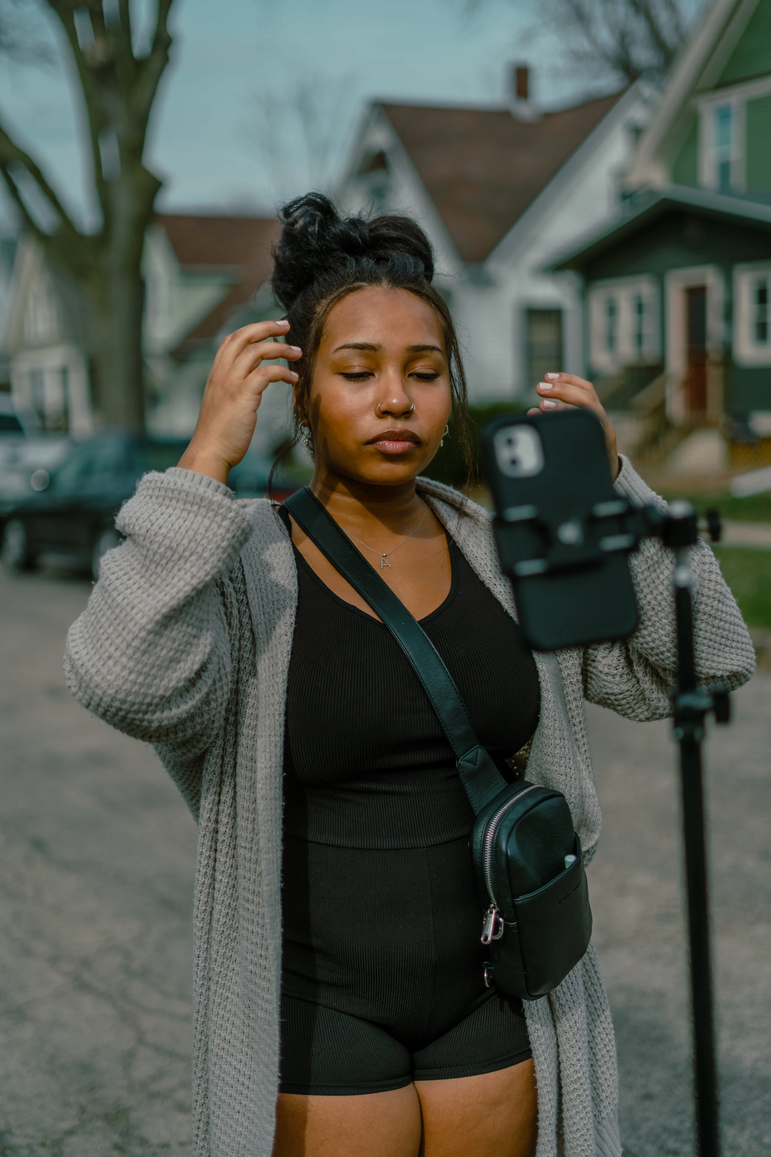 A UGC CONTENT CREATOR GETTING READY TO RECORD CONTENT IN THE MIDDLE OF A STREET