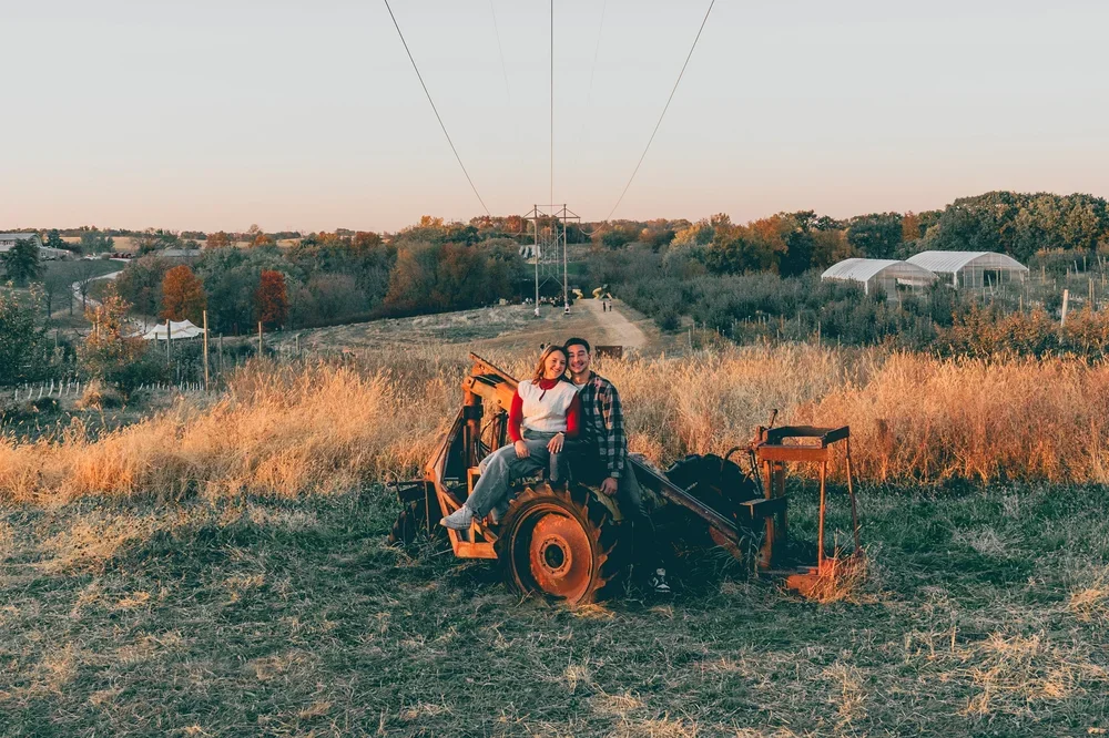 IOWA CITY PORTRAIT PHOTOGRAPHER - PHOTOS OF A COUPLE SITTING ON A TRACTOR AT wilson's orchard and farm IOWA CITY, IOWA