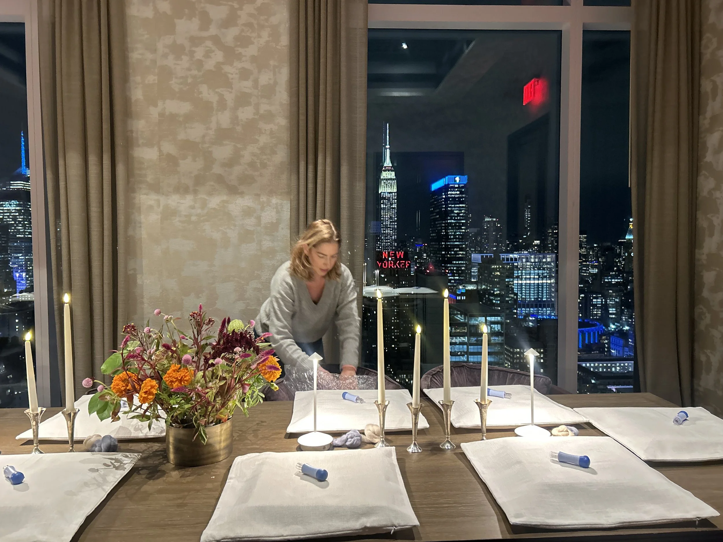 Table set for a private event by Le Studio Anthost, New York, with a skyline view and floral centerpiece.