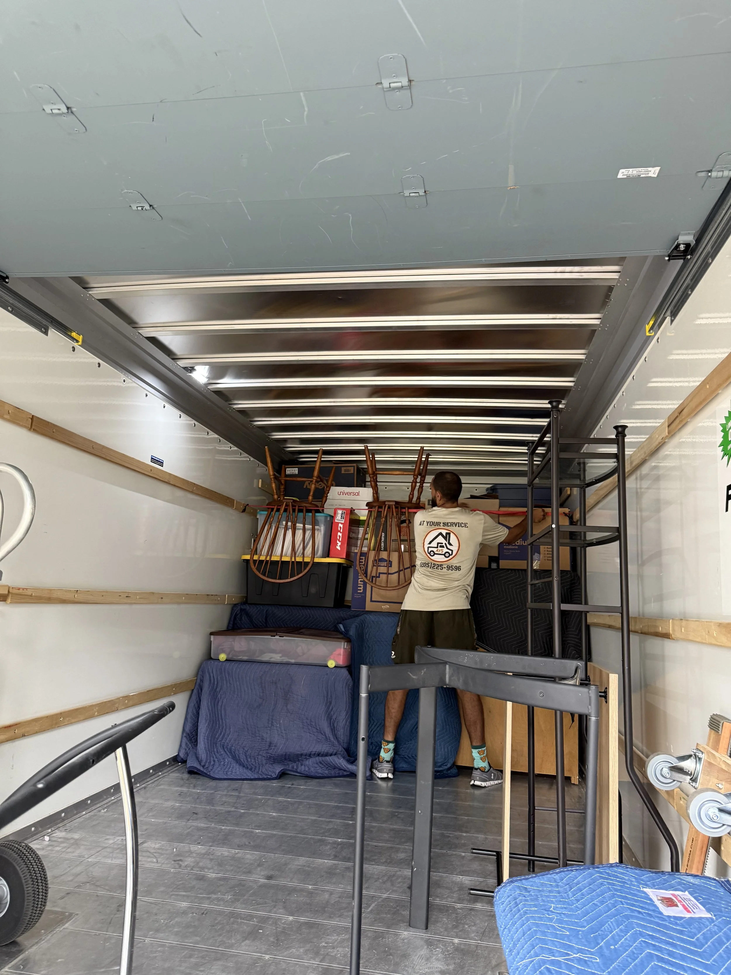 A man packing items into the back of a moving truck