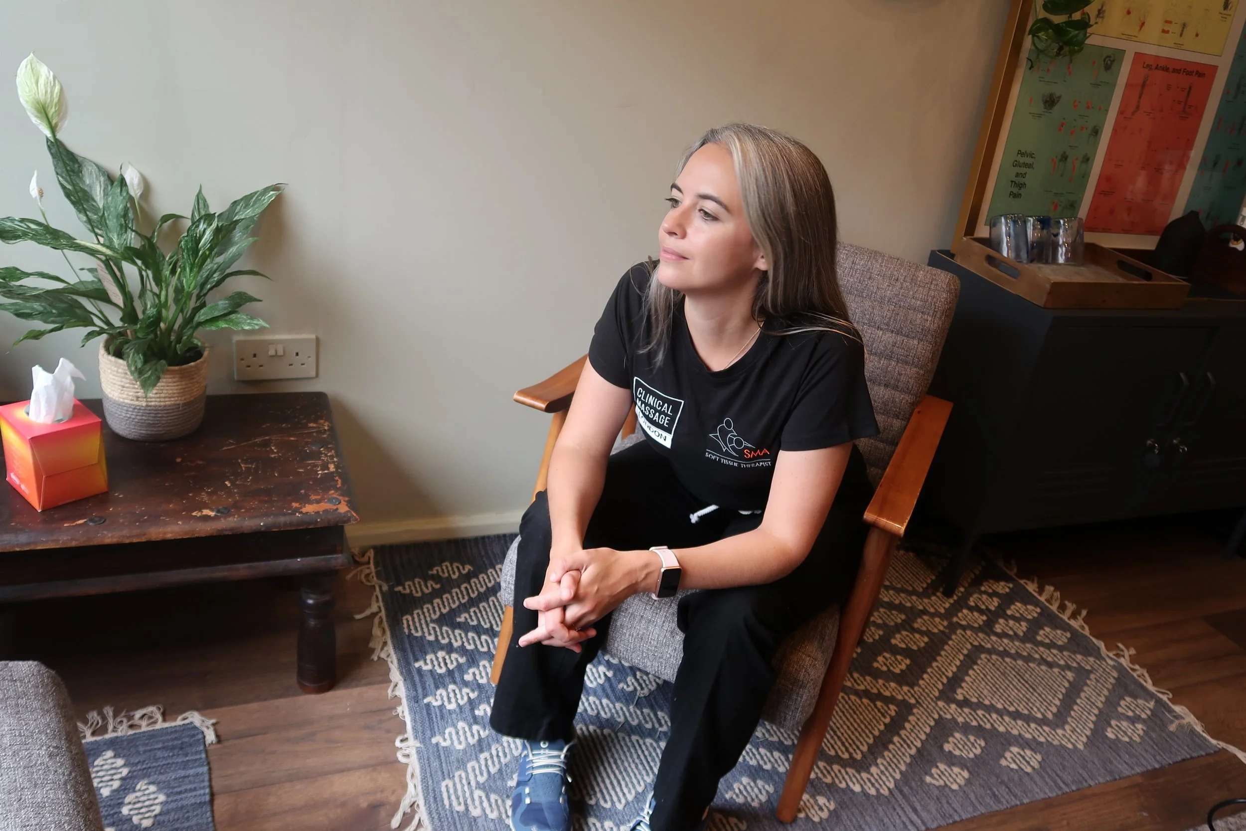 massage therapist sitting in chair looking away