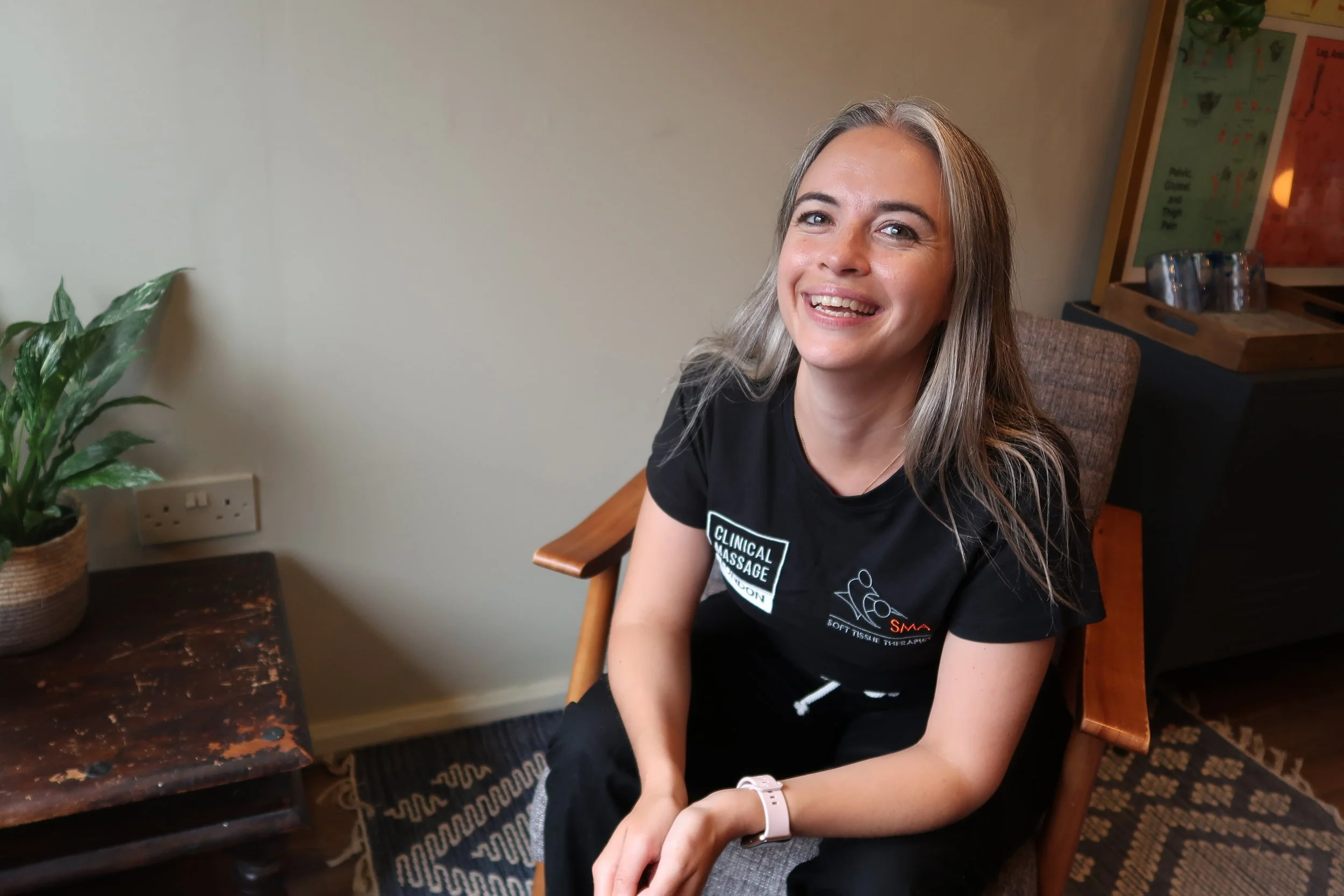 female massage therapist looking and smiling at camera