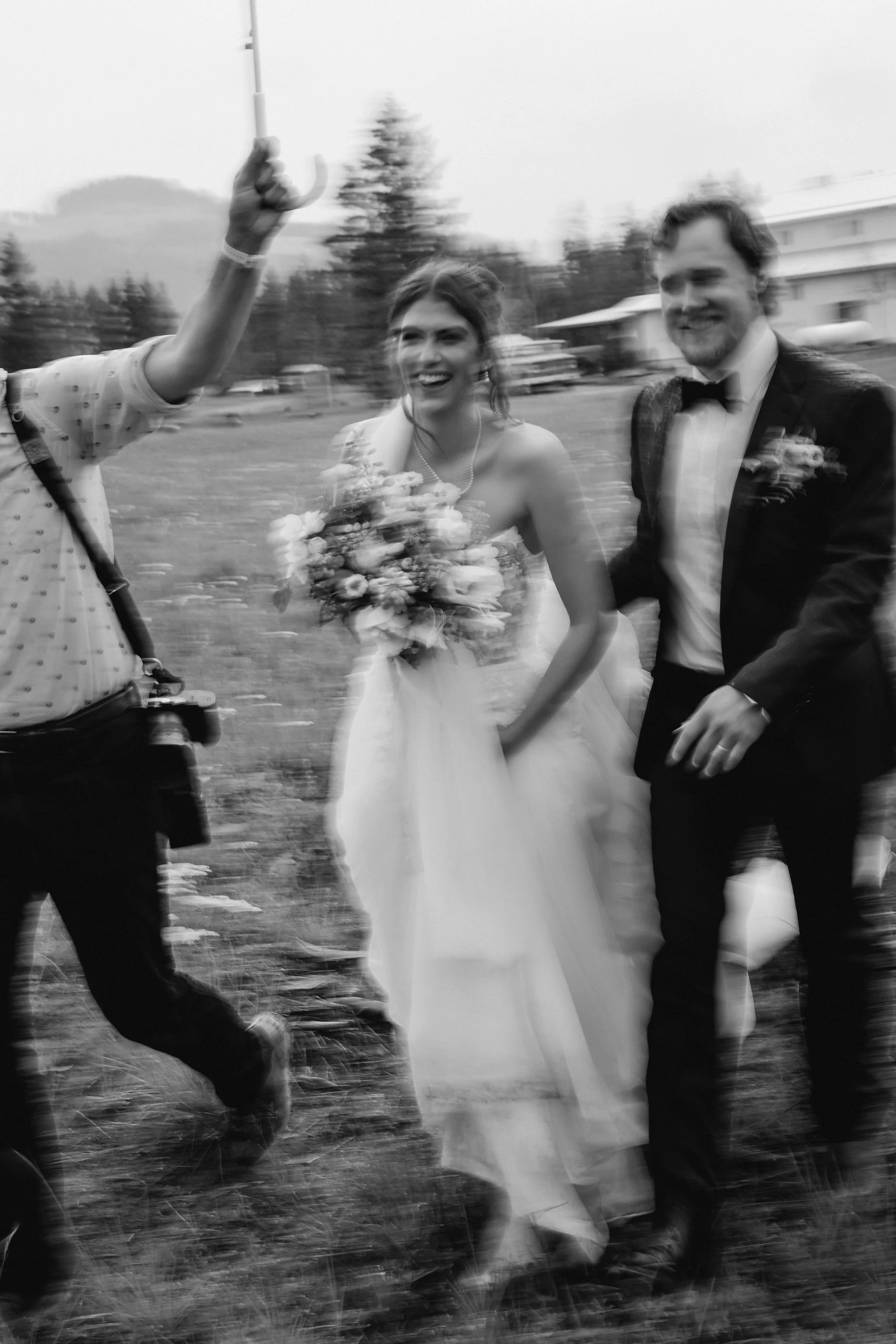 Bride and groom walking hand in hand through the rain at a Western chic BC wedding.