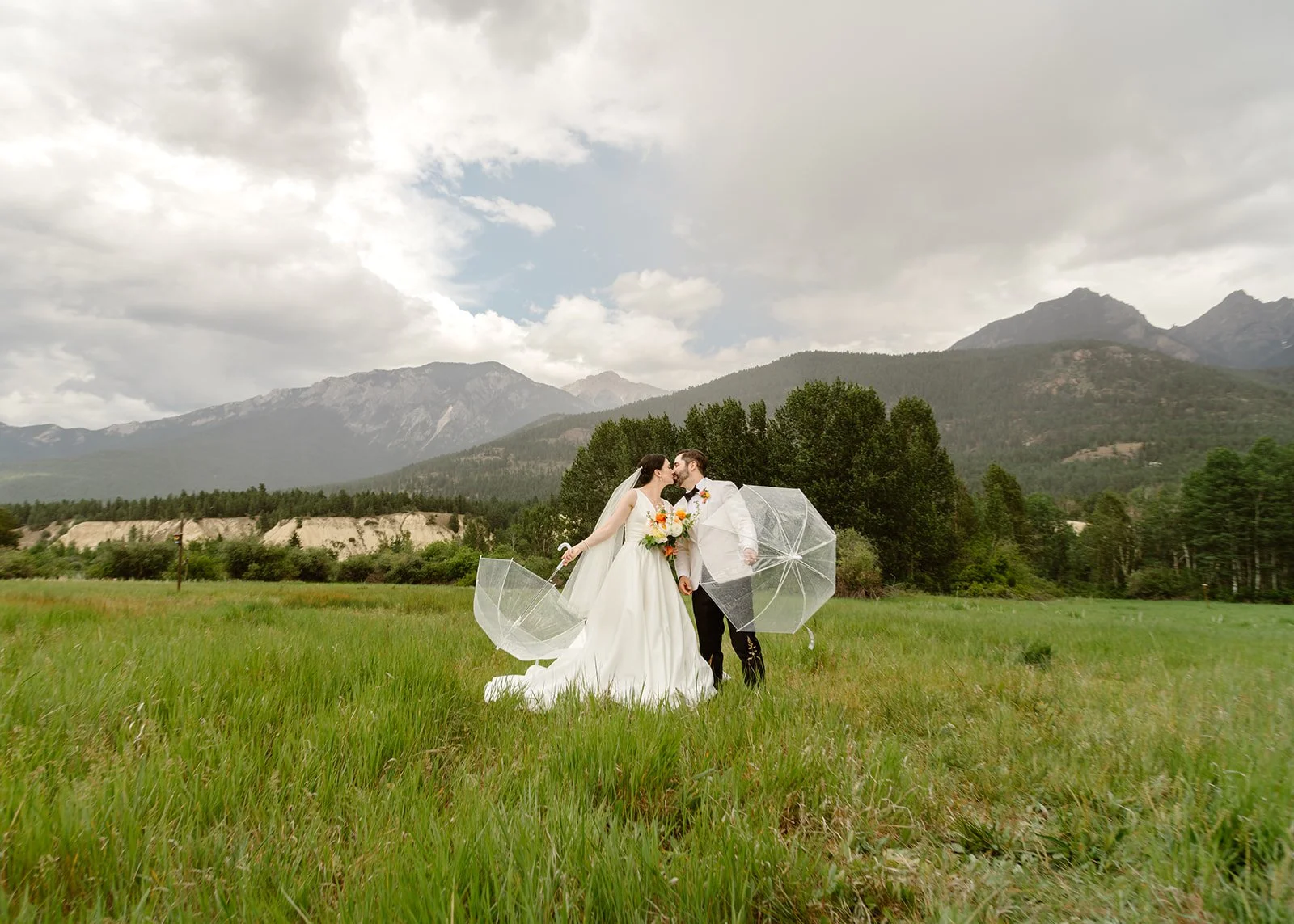 Romantic Mountain Wedding: Couple kissing under the rain
