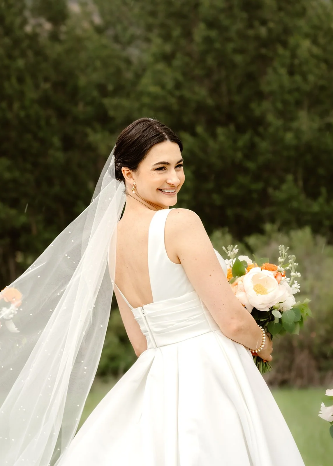 Romantic Mountain Wedding: Bride Smiling with Bouquet