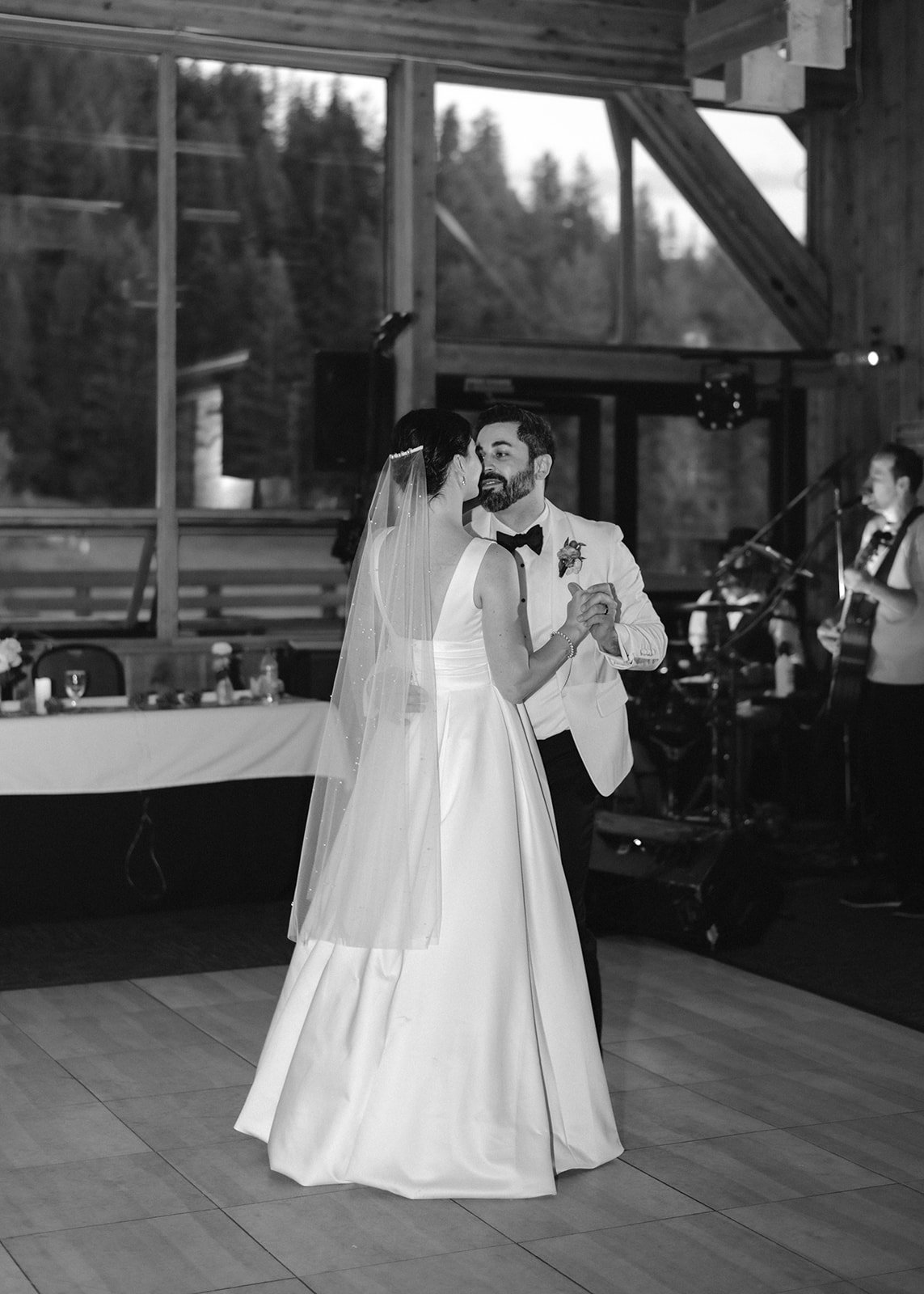 The couple shares a dance during their romantic mountain wedding reception, captured in a timeless black and white photo.