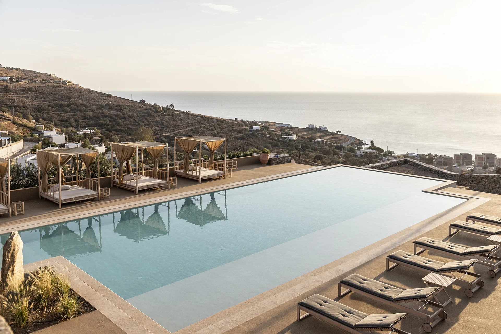Villa Nāos is a luxury 9-bedroom villa in Koundouros, Kea, Greece, designed for up to 18 guests, blending bohemian style with natural stone architecture. Infinity pool overlooking Aegean Sea views and landscaped gardens. Wild Thing Yoga, Lauren Clark