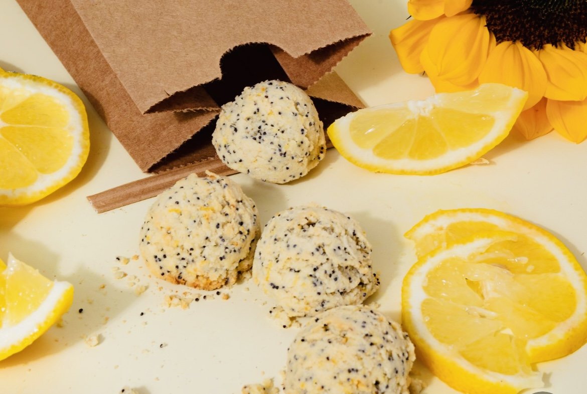 Lemon poppy seed cookies with lemon slices and brown paper bag.