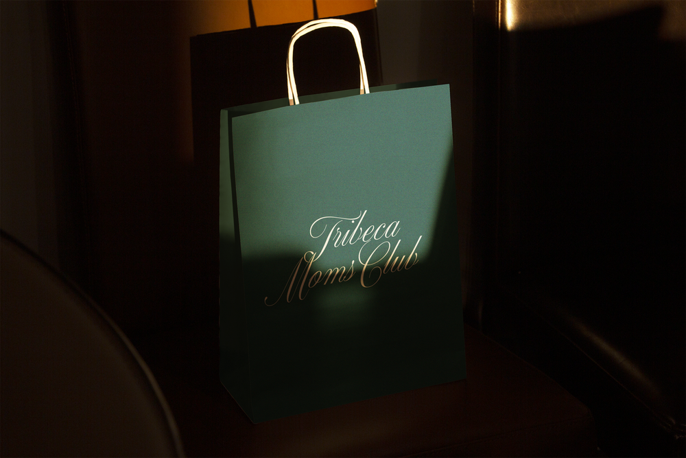 A hunter green shopping bag with the script logo