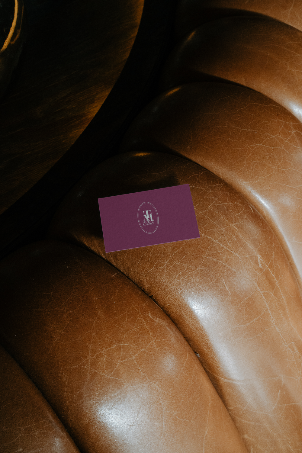 A magenta business card on a leather chair