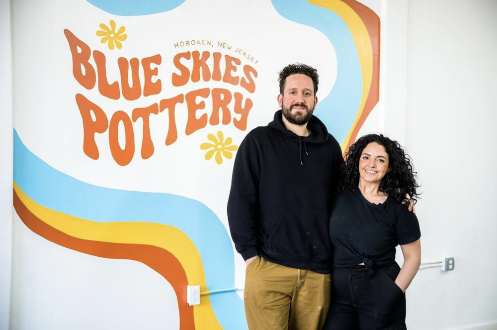 Valerie and Jordan in front of the logo mural in Hoboken