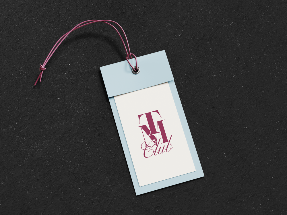 A hang tag with the stacked TM Club monogram