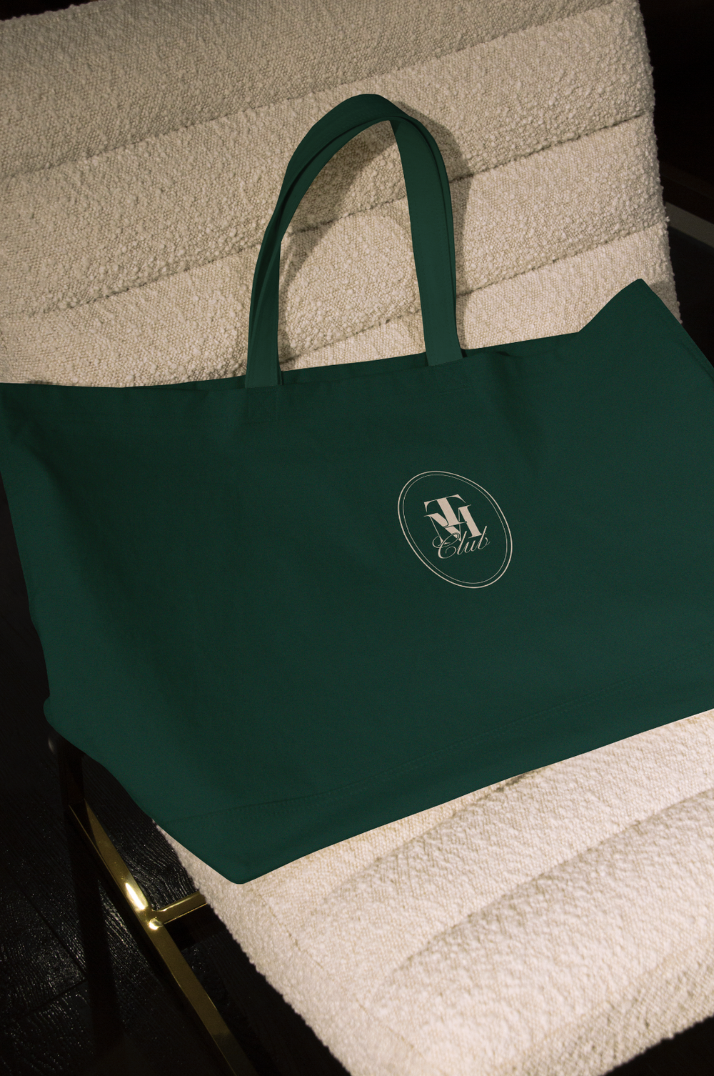 A hunter green tote with the oval monogram