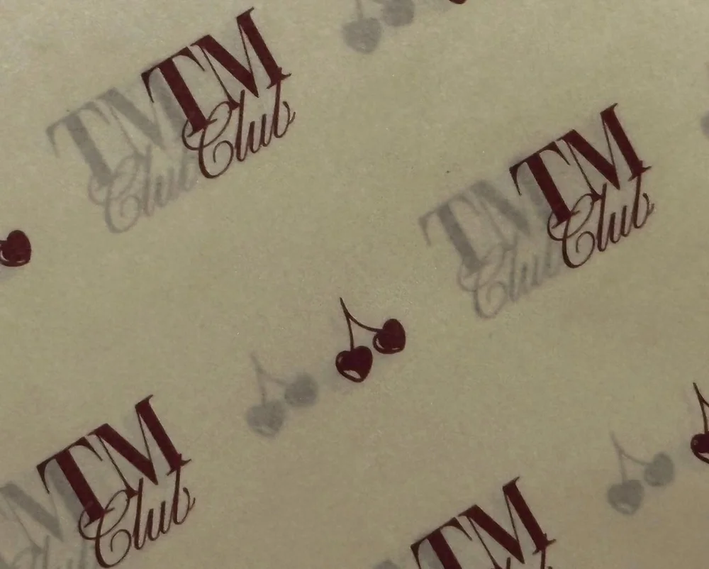 The monogram + cherry brand pattern printed on cream