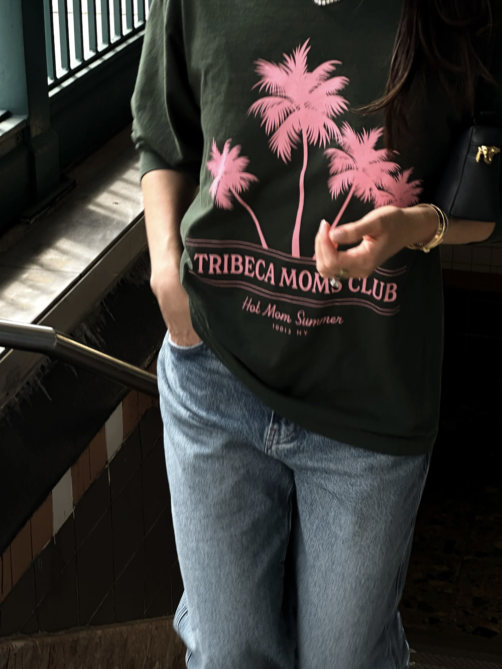 The pink palm tree graphic on a dark green crewneck