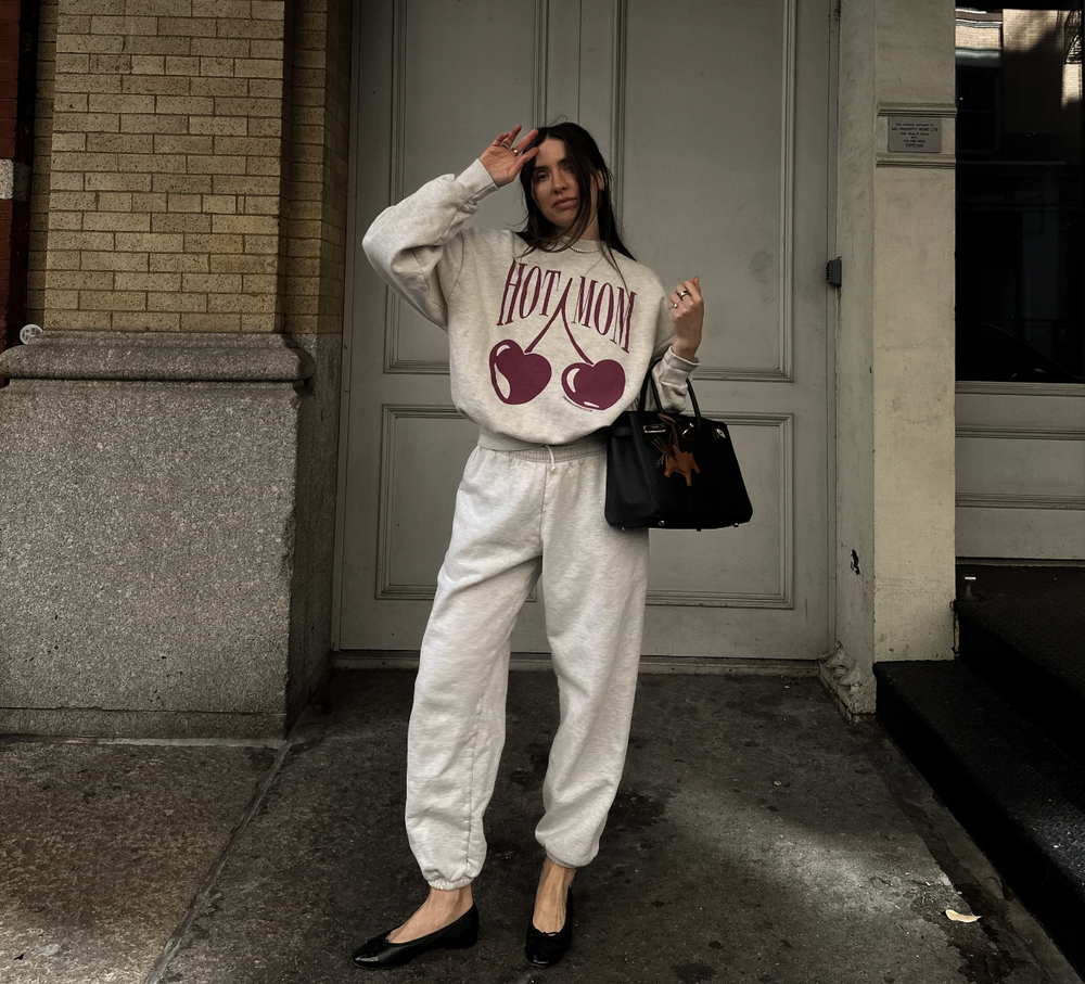 Madison in the HOT MOM cherry sweatsuit outside a brownstone