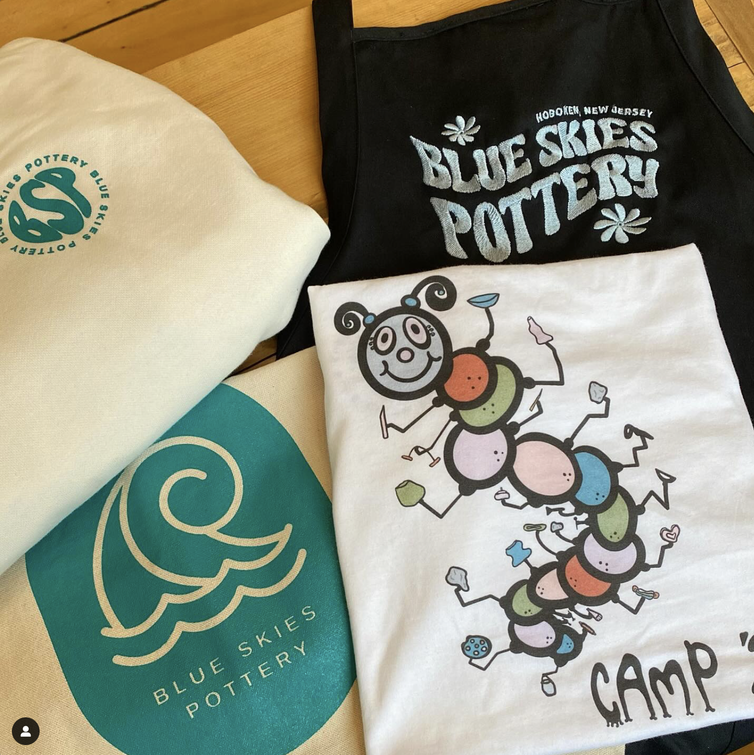 Blue Skies Pottery merch: the BSP sweatshirt, the wave submark, and an apron
