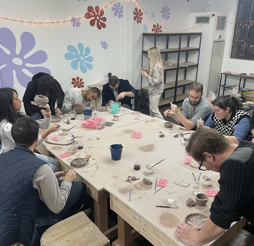 A class at the big table under the flower wall