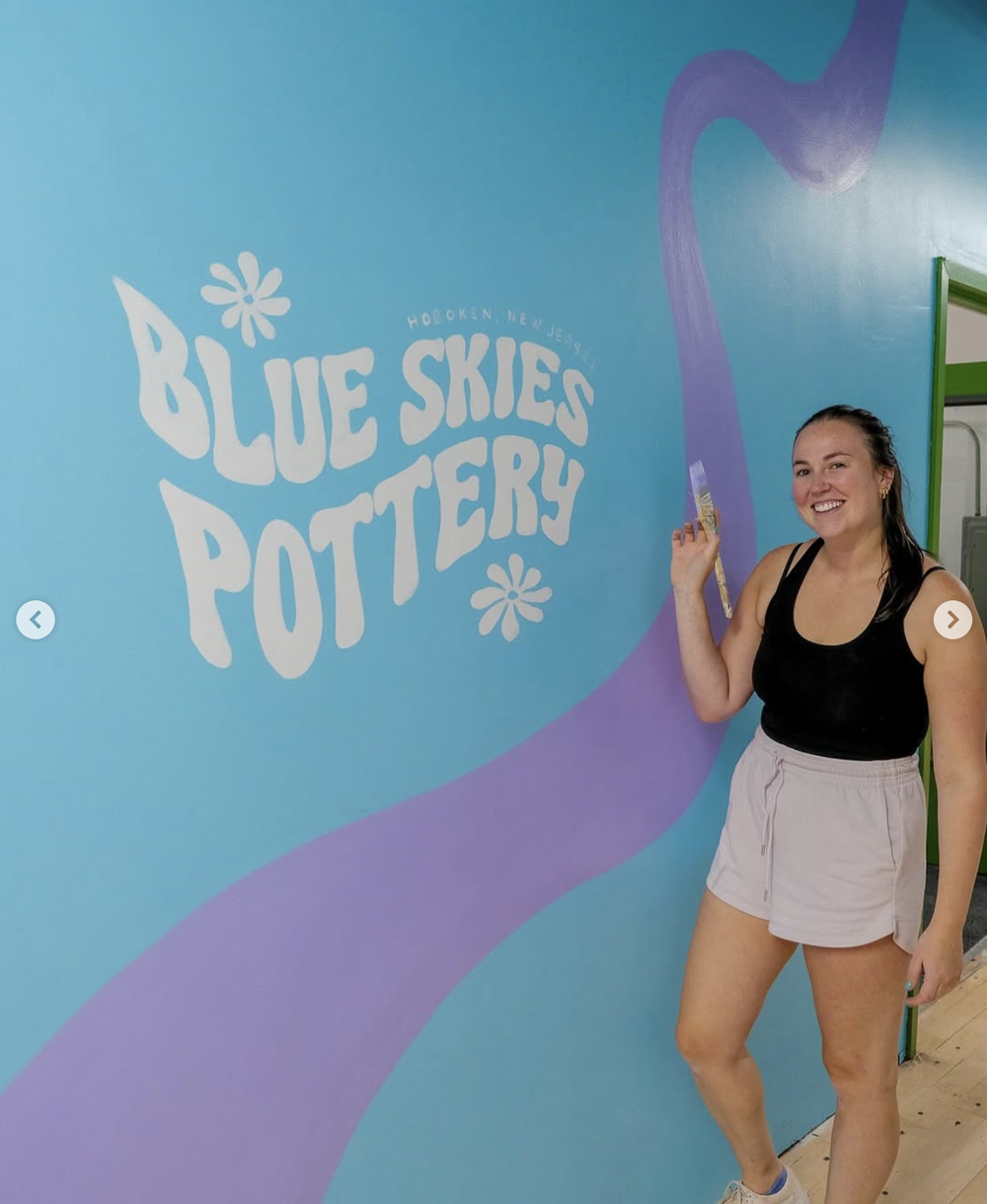 Posing by the wavy logo mural