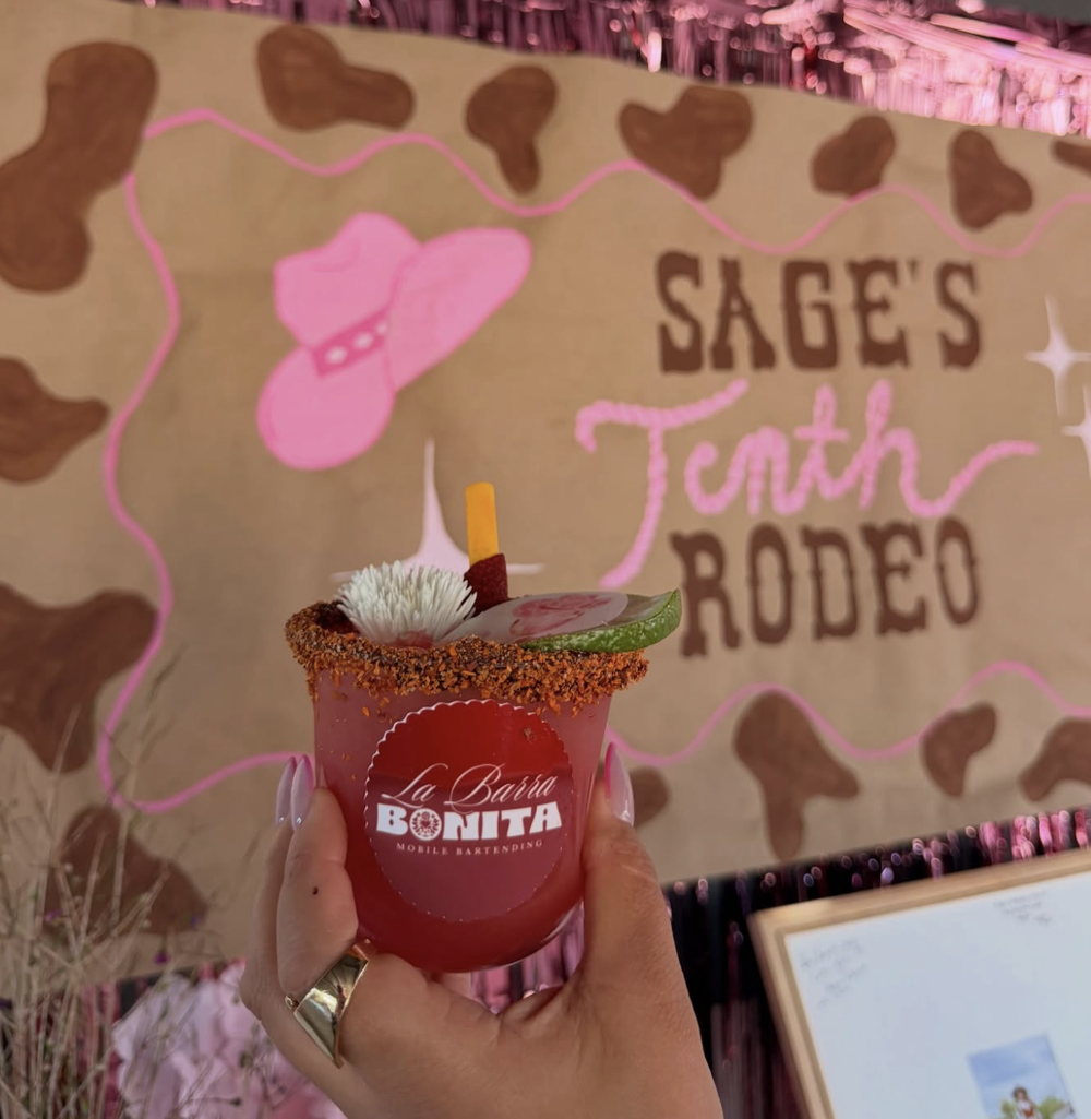 A cocktail with the round La Barra Bonita sticker at a rodeo-themed birthday party