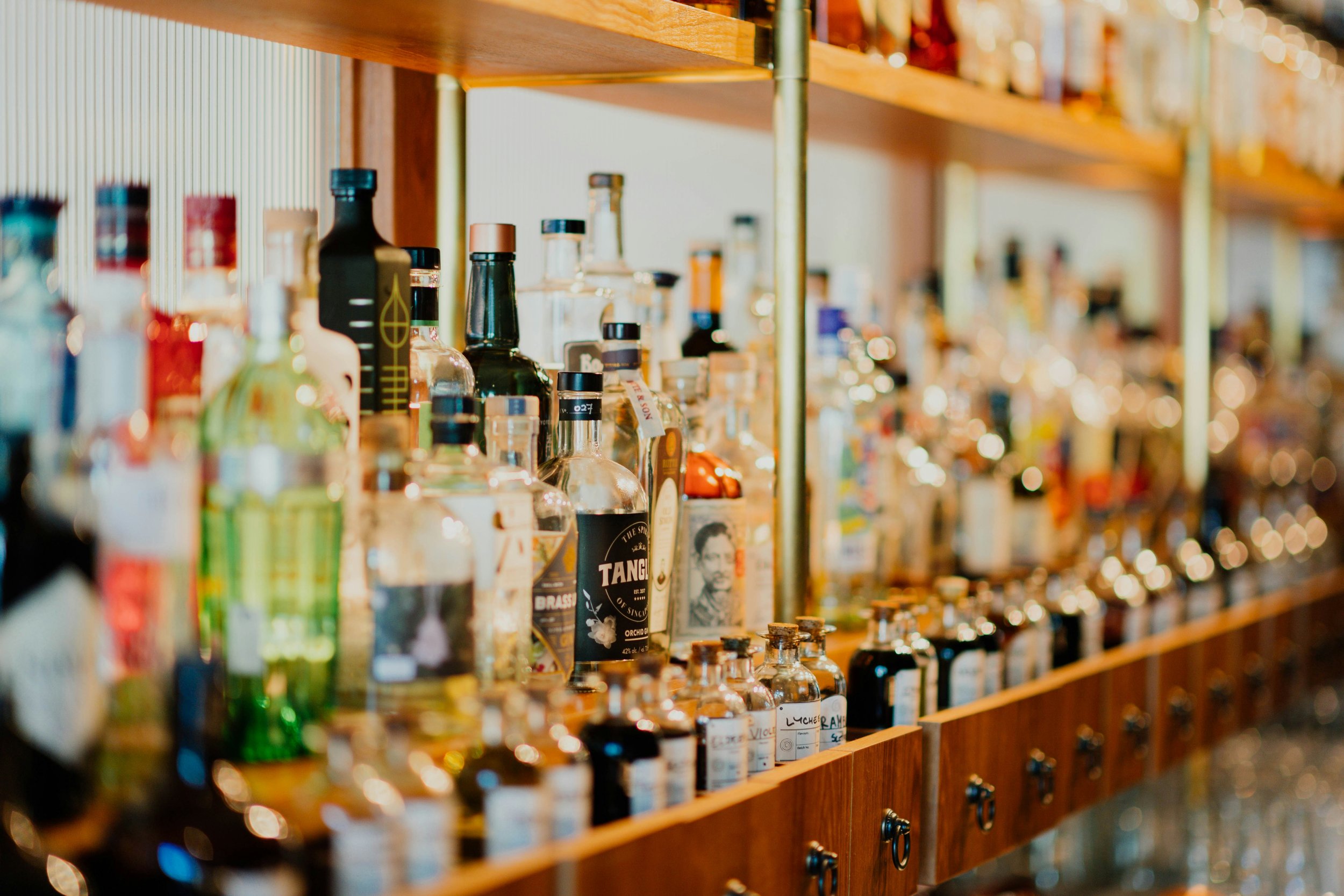 Shelves filled with various bottles of alcohol in a bar or store.