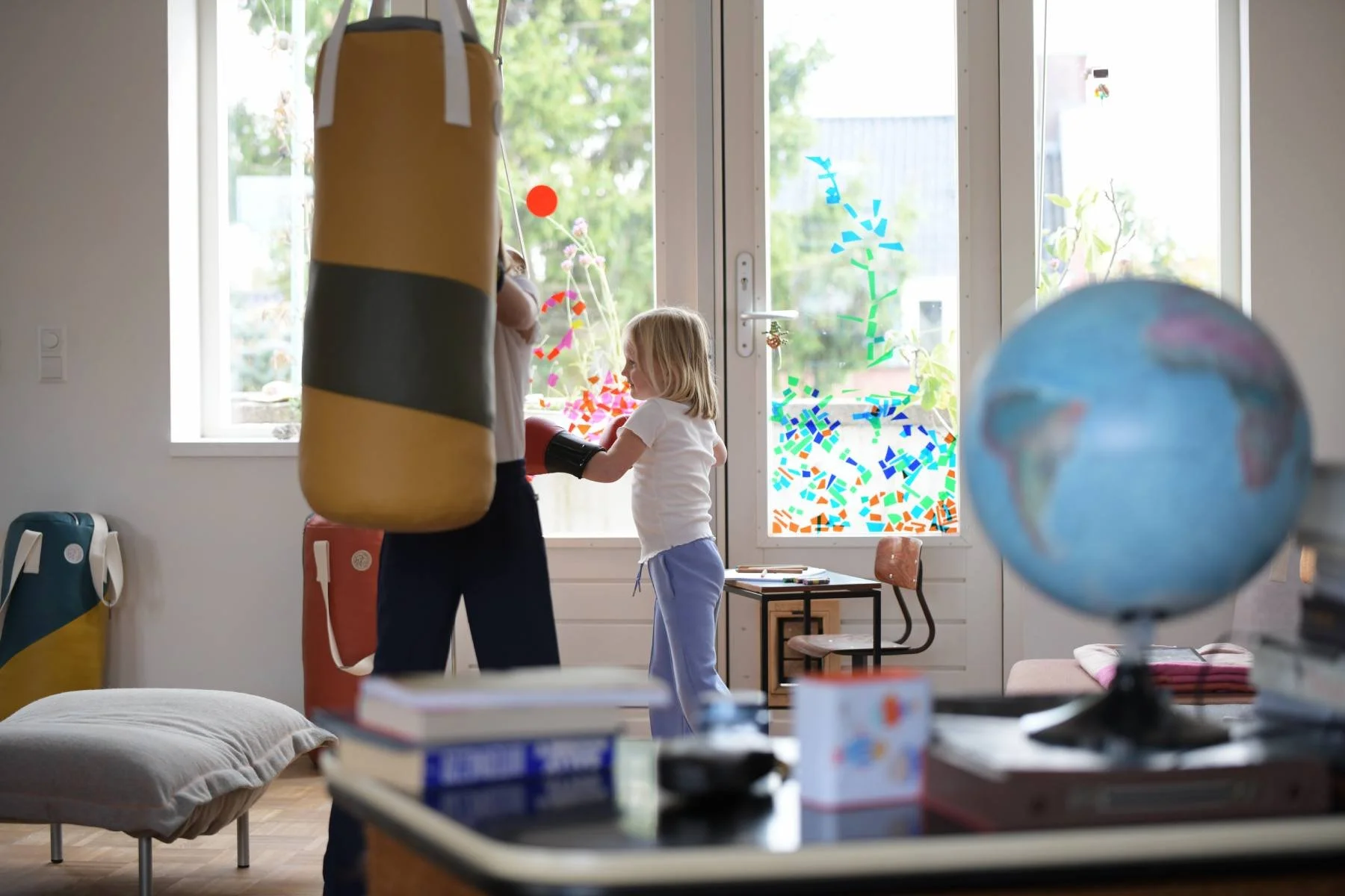 Two schoolgirls in a living room with a punching bag and a globe