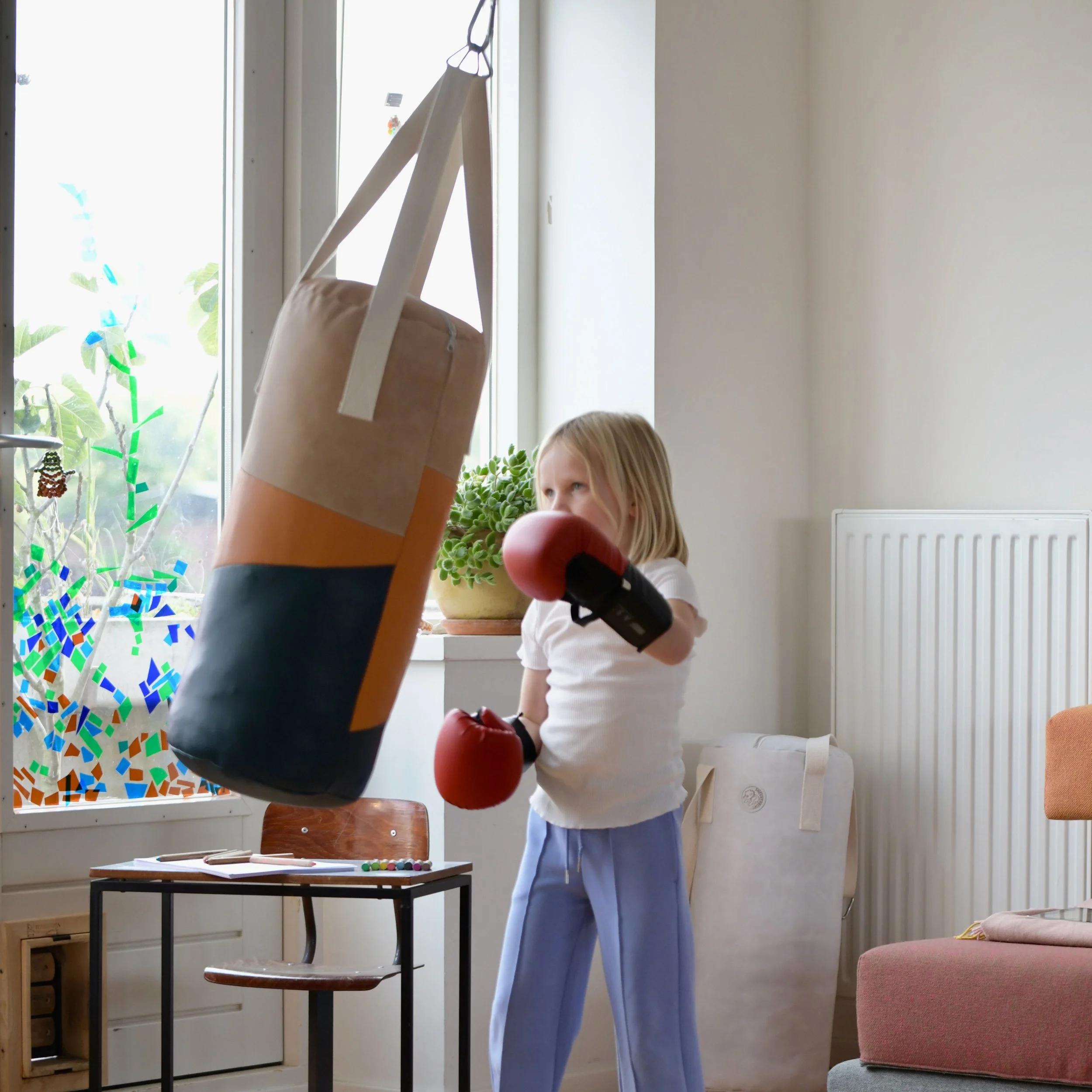 A 6-year-old girl is punching a punching bag