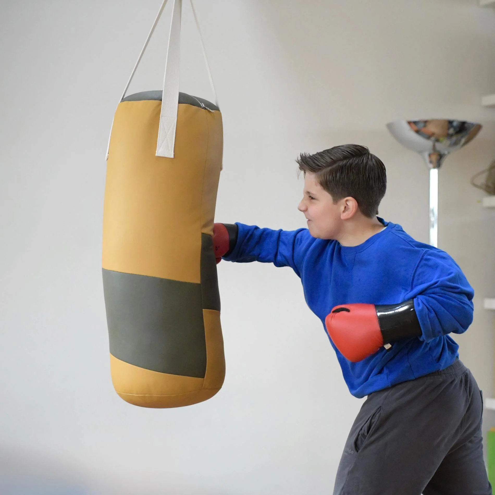 ein junge boxt kraftvoll auf einen Boxsack