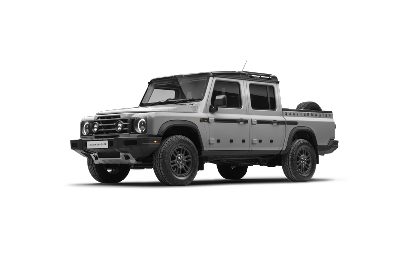 Gray off-road pickup truck with four doors, black wheels, spare tire on the back, and a small antenna on the roof, set against a black background.