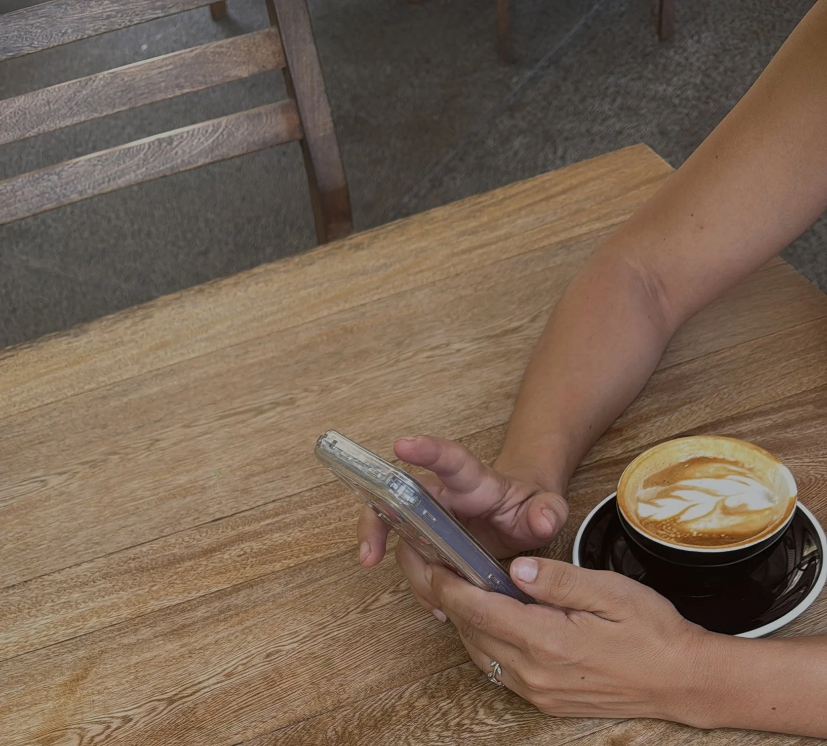 Business owner reviewing financial information on phone with coffee, representing clarity gained from a redesigned chart of accounts for Civic Square