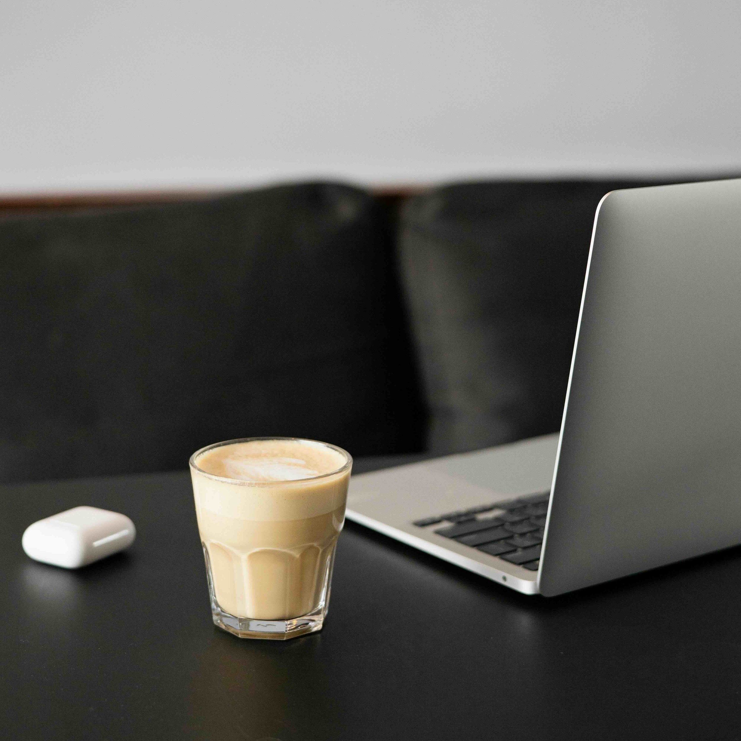 A calm workspace with coffee and a laptop, reflecting thoughtful planning and steady business growth.