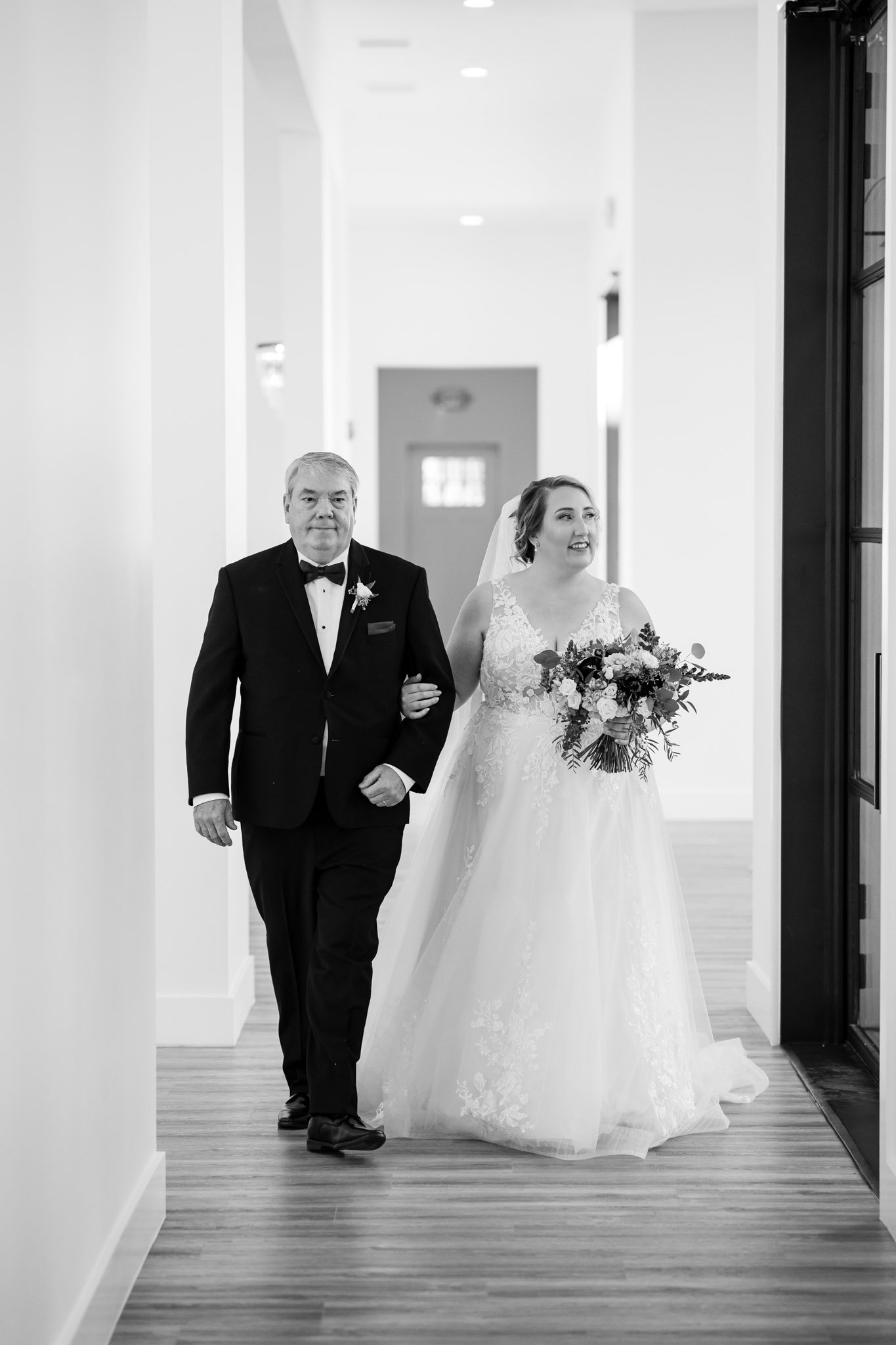 Bride holding a bouquet escorted by her father to the ceremony at The Arlo Austin TX The Amber Studio
